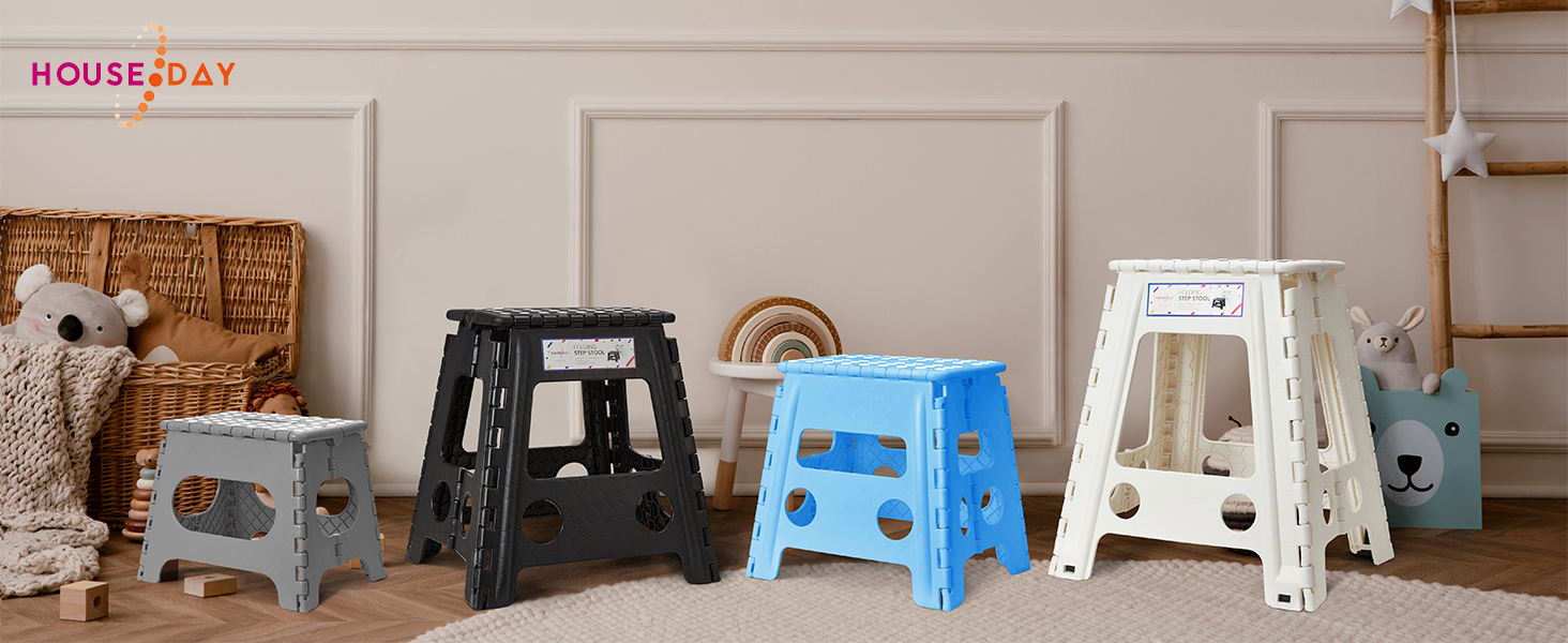 Quatre escabeaux pliants de différentes couleurs : noir, bleu, blanc et vue partielle d'un autre. Présenté sur un plancher de bois contre un mur de couleur claire